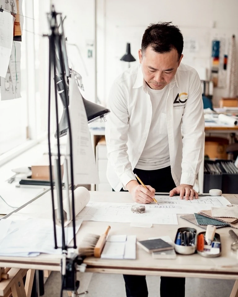 Allen Liu at a drafting table, marking up a floor plan